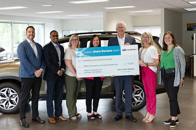 Group of people standing inside a car dealership